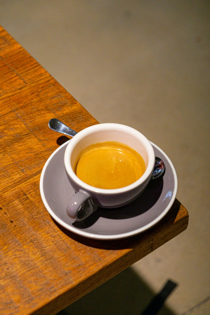 a cup of coffee on a saucer on a wooden table